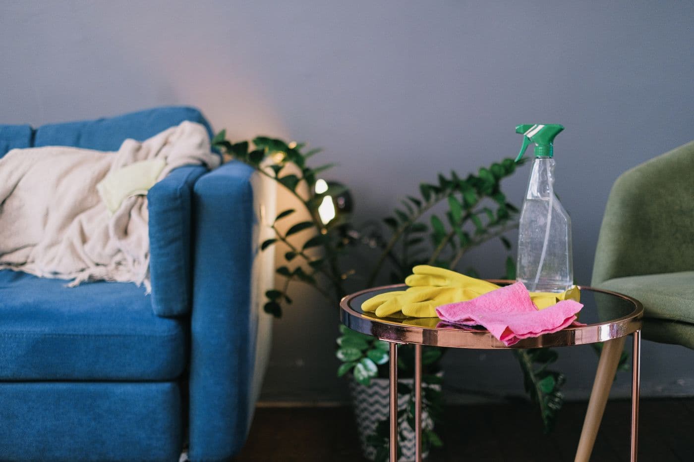 Gants, chiffon et vaporisateur d'entretien posés sur une table de salon